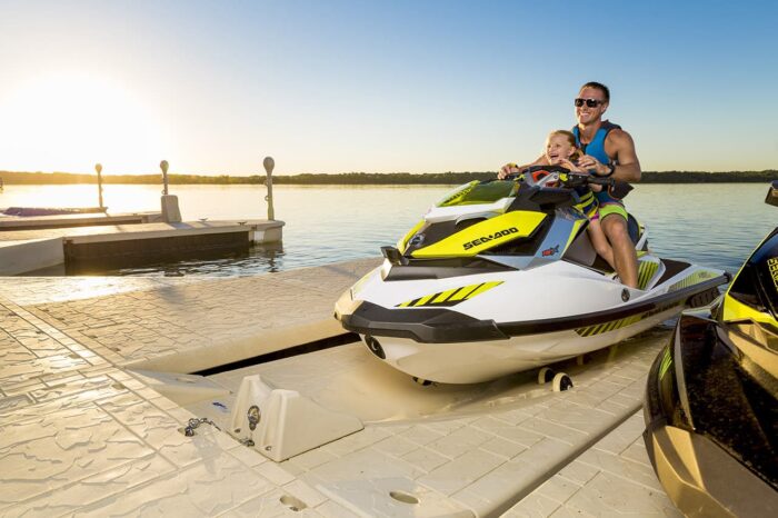 A man and little girl are happy to use an SLX6 PWC port to moor their jet ski.